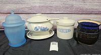 Four containers lined up: blue frosted glass jar, Pfaltzgraff tureen on underplate with ladle, Pfaltzgraff cookie jar, signed glazed pottery jar