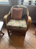 Front view of rattan armchair with cushions and pillow