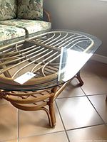 Full view of coffee table with glass top and rattan frame