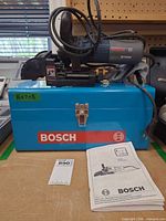 Bosch B1650 plate joiner atop blue Bosch metal case with manual visible