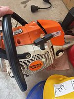 Top view of Stihl MS270 chainsaw showing handle, casing and part of accessories