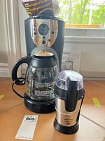 Front view of Oster coffee maker, Black & Decker grinder, and manuals
