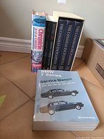 All six books standing, showing spines and BMW manual cover