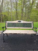 Front view of cast iron and wood bench showing full structure, lattice backrest, wood slats