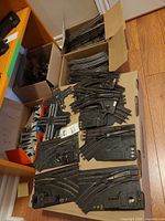 Boxes of curved track sections and array of switch tracks on cardboard