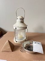 group shot of lantern, pyramid paperweight, and pewter dish