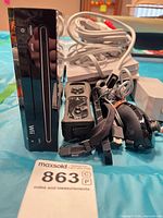 Front view of Nintendo Wii console with remote, cables visible