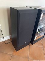 Front view of left speaker showing grille and Panasonic badge
