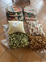 Group shot of throw pillows and two stacks of seat cushions