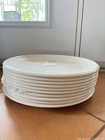 Stack of ten white plates side view