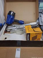 Nailer, magazine, plastic parts and Bostitch nail box inside Power Fist carton