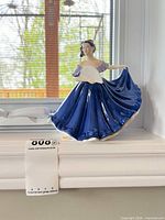 Full view of Royal Doulton Elaine figurine on windowsill