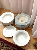 Stacks of white bowls, stack of blue-rim floral bowls, two plain bowls