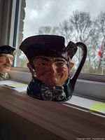 Front view of Old Charley jug showing winking face and hat spout