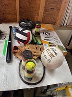 Lot overview with volleyballs, bat, glove, rackets, tennis balls and boxed net