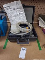 Power painter in open case with hose, container and manual visible