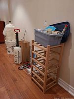 Group view of carboys, corker, rack, tote and accessories along wall