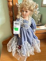 Full front view of blue Victorian style porcelain doll on dresser
