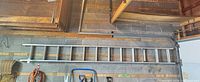 Full length of aluminum extension ladder mounted on wall