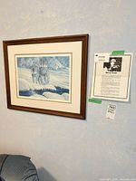 Full view of framed wolf print with artist info sheet visible