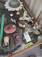 Top view of all figurines on table including Sandicast dog, sleeping animals in baskets, squirrel group