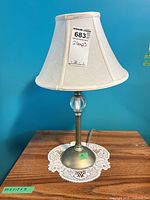 Full view of lamp with shade on wooden surface