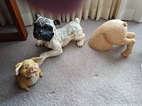 Bulldog, pig head, and pig hindquarters coin banks on carpet