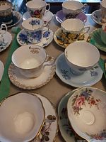 Overhead view of eleven teacup and saucer sets