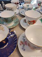 Group of assorted floral bone china teacups and saucers