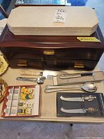Overview of lot with flatware chest, John Palmer box, loose utensils and boxed accessory sets