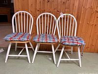 Front view of three dining chairs with cushions