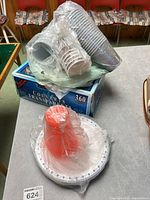 Boxed clear plastic cutlery set, cups on top, plates and squeeze bottle bagged
