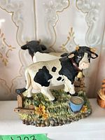 Resin Holstein cow figurine, front and rear cows on grassy base with fence and pail