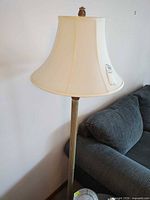 Full view of lamp beside sofa showing shade and upper column