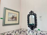 Wall view showing framed print and ornate mirror together