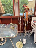 Group view of plant stand, scarecrow stake, several decorative stakes, ceramic rabbit and plaque