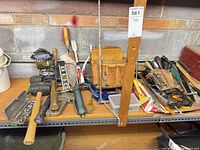 Shelf holding assorted hand tools, leather pouch, clamps and socket case