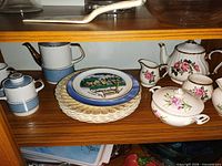 Shelf view showing both tea sets and stack of plates