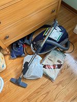 Vacuum canister with hose, wand, floor nozzle and accessories on floor