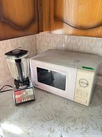 Microwave and blender together on countertop