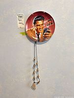 Elvis ceramic plate and beaded skeleton-hand necklace hanging on wall