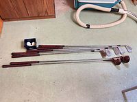 Seven clubs and tray with three golf balls on basement floor