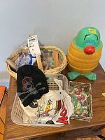All lot items together: coin bank, wicker basket with coin rolls, beanie, towel, napkins, storage basket
