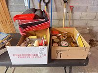 Two boxes on table containing painting supplies and hardware
