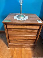 Front view of nightstand showing three drawers and overall finish