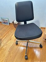Front view of black swivel office chair on chrome base with casters