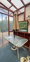 Full view of table with umbrella and base in sunroom