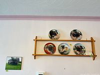 Overall view of rack, five plates, and framed barn print mounted on wall