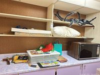 Shelf with spider decoration, pillow, crucifix, banner, storage bin, tissue paper, gift bags