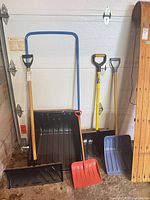 All four shovels standing against garage door
